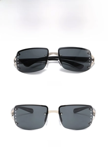 Close-up of frameless oversized sunglasses with gold metal temples and rhinestone accents