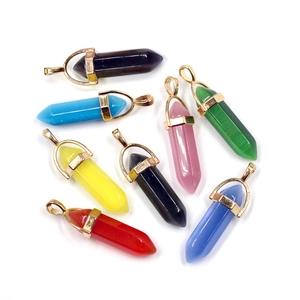 Flat lay of eight colorful hexagonal crystal pillar pendants with metal caps on white