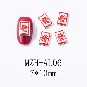 Macro view of silver mahjong nail charm with red Fa character on dark red manicure