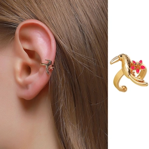 Macro detail of golden hummingbird ear cuff with pink flower and earring on model ear