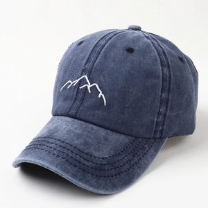 Close-up of washed blue cotton baseball cap with white mountain peak embroidery