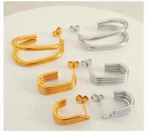 Detail view of multi-layer geometric C-shaped earrings in gold and silver finishes