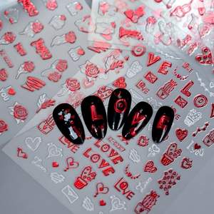 Detail showing red metallic heart and LOVE stickers applied on black false nails