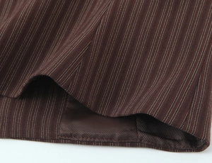 Detailed macro view of brown pinstripe fabric texture and stitching on suit pants