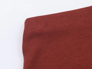 Gros plan sur la texture du tissu tricoté rouge foncé avec tissage haute densité