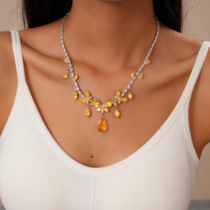 Macro view of silver butterfly necklace with yellow teardrop crystals and pavé stones