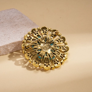 Detailed back view of a vintage gold openwork flower brooch with pin clasp.
