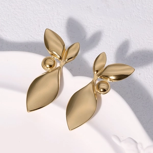 Elegant 18k gold plated titanium steel leaf earrings with round bead on white plate