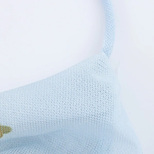 Vue macro de la texture en maille bleu clair et de l'attache de l'élastique du masque