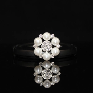 Exquisite pearl and rhinestone alloy flower button with mirror reflection on black background