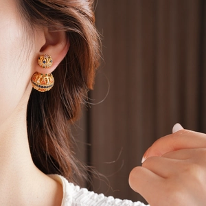 Gros plan sur les boucles d'oreilles sphériques en or 18 carats avec zircons colorés