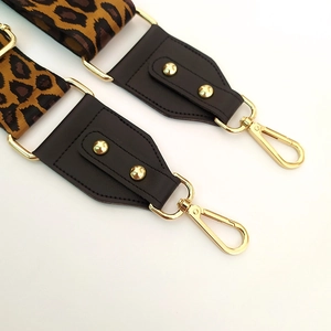 Detail of leopard print bag strap with golden swivel hook and dark brown leather end
