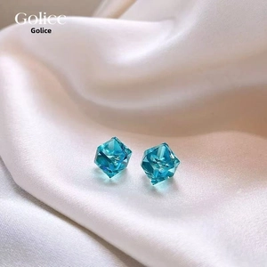 Gros plan de boucles d'oreilles cube bleu menthe en verre facetté au design élégant