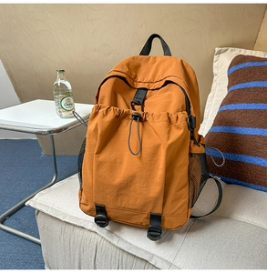 Details des orangen Nylonrucksacks mit elastischem Kordelzug und seitlicher Netztasche