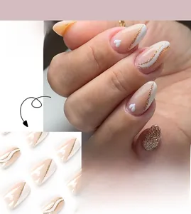 Detail of French tip press-on nails with white borders, gold glitter, and small hearts