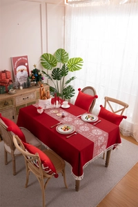 Close-up of red Christmas tablecloth with white snowflake prints and tassel fringe detail