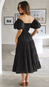 Detail of the back elastic ruching and puffed sleeves on the black off-shoulder midi dress
