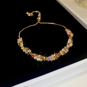 Macro view of a gold plated adjustable bracelet with multicolored faceted gemstones