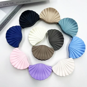 Flat lay of colorful textured shell-shaped matte hair claws on a white background