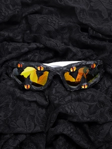 Gothic sunglasses with orange bionic eyes and lava texture on black lace background