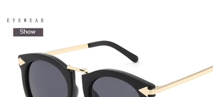 Detail of vintage cat-eye sunglasses featuring black frame and gold metal temples