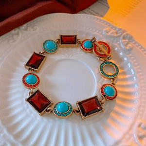 Macro detail of vintage gold bracelet with red gems, turquoise stones and OT clasp
