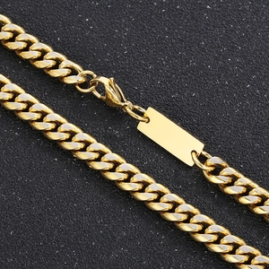 Macro shot of gold Cuban chain necklace focusing on lobster clasp and rectangular tag