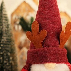 Detail of Christmas gnome showing red felt hat with reindeer antlers and white fiber beard