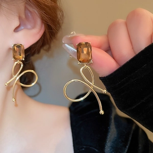 Close-up of elegant amber gemstone dangle earrings with gold streamlined design