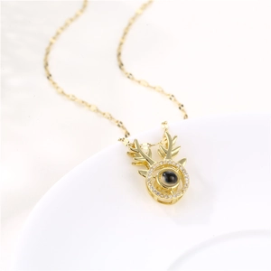 Golden stag antler necklace with zircon stone on white plate in professional close-up shot