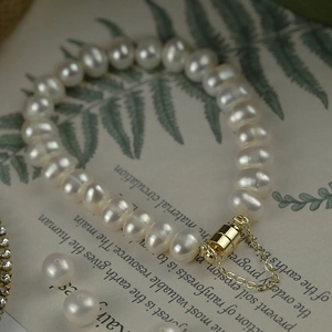 Detail of freshwater pearl bracelet with a golden magnetic clasp and safety chain