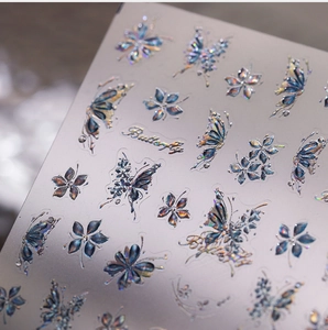 Macro view of 3D embossed butterfly and flower nail stickers with holographic effect