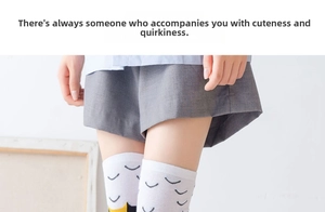 Detail of white Japanese style knee-high socks featuring cute cartoon cat patterns