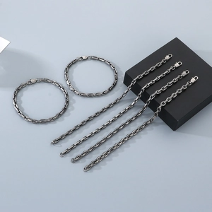 Détail de l'ensemble de colliers et bracelets à maillons groin de porc en acier argenté