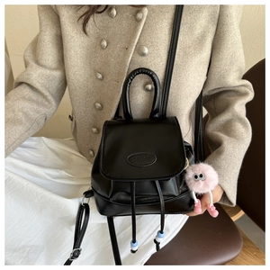 Mini zaino in pelle nera con coulisse e dettaglio ciondolo in peluche rosa