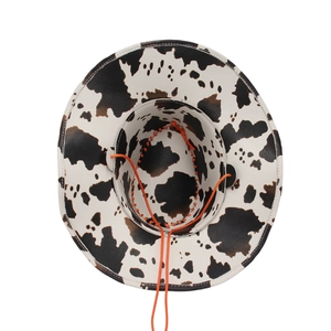 Detailed top view of cow print cowboy hat with texture and orange adjustable chin strap