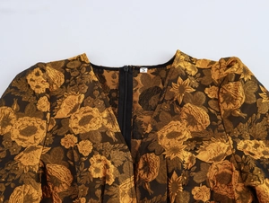 Detailopname van gouden jacquardjurk met V-hals, maatlabel S en rits aan de achterkant