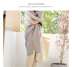 Detail of a large cream canvas tote bag paired with casual grey streetwear for women