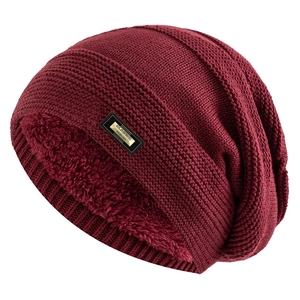 Close-up of thick wine red knit beanie with warm fleece lining and metal classic tag