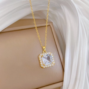 Elegant gold titanium necklace with micro-paved cubic zirconia square pendant on silk background
