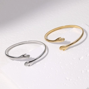 Minimalistische Edelstahl-Armreifen mit Umarmung-Hände-Motiv in Gold und Silber-Optik