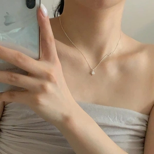 Mirror selfie showing a silver eight-pointed star pendant necklace with zircon stone
