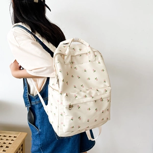Detailed side view of floral canvas backpack with pink flowers on off-white fabric