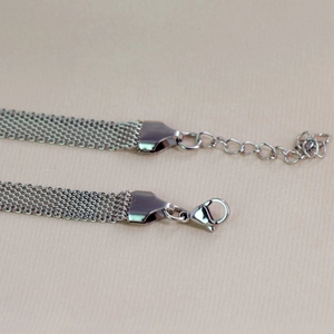 Close-up of silver mesh choker with lobster clasp and adjustable extension chain detail