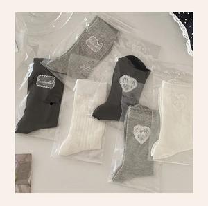 Detail of mesh socks in black, grey and cream with sweet heart lace patches