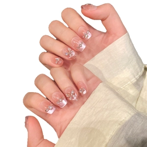 Pink gradient French press-on nails featuring sparkling rhinestone butterfly accents
