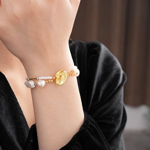 Detail of gold-plated double-layer bracelet with baroque freshwater pearls on wrist
