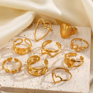 Detailliertes Set aus neun 18k vergoldeten Herzringen auf einer Premium-Steinfläche