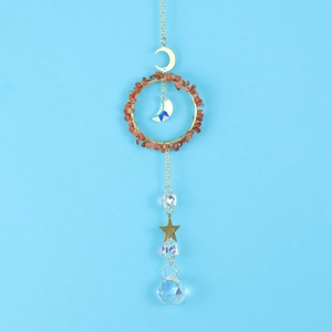 Macro detail of suncatcher crystal pendant with red agate stones and golden metal stars