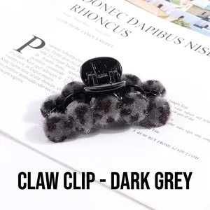Detail view of dark grey plush claw clip with leopard pattern fur balls for women